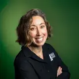 smiling woman in black shirt on green background
