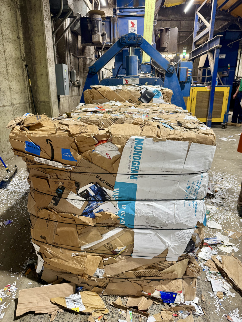 bale of cardboard in front of a blue recycling baler