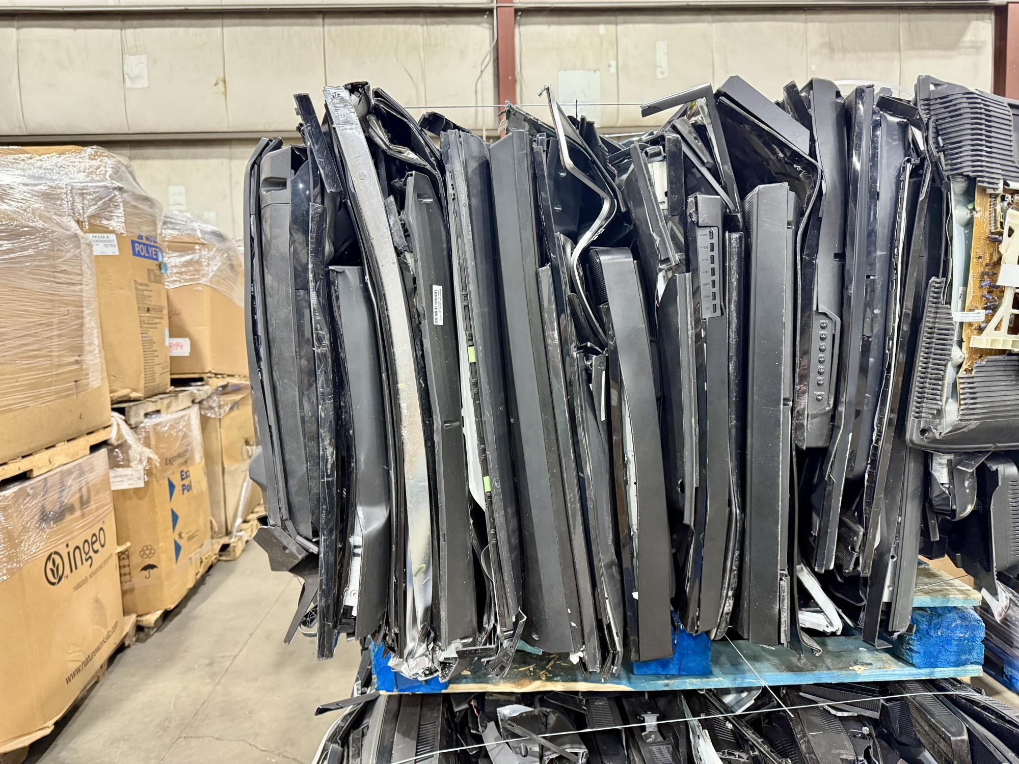 pallet of stacked flat screen tvs