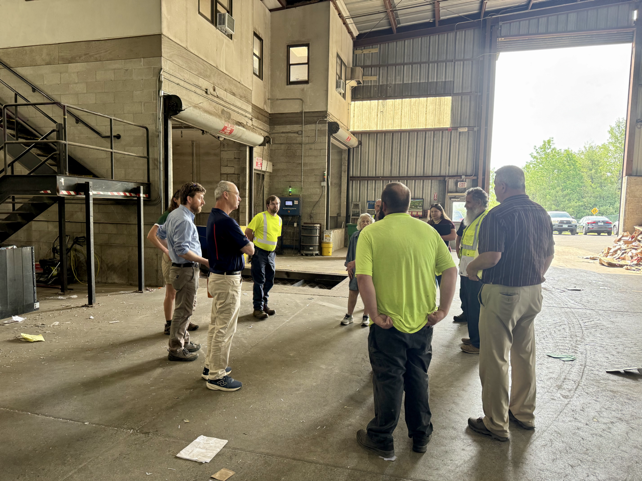 tour group standing in front of a walking floor that moves recyclables