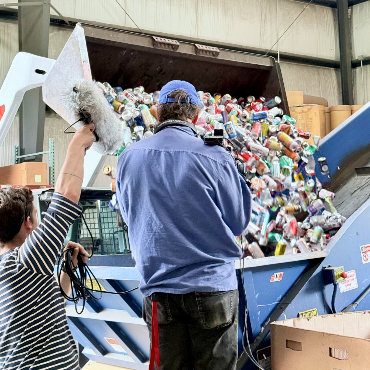 two people filming aluminum being baled