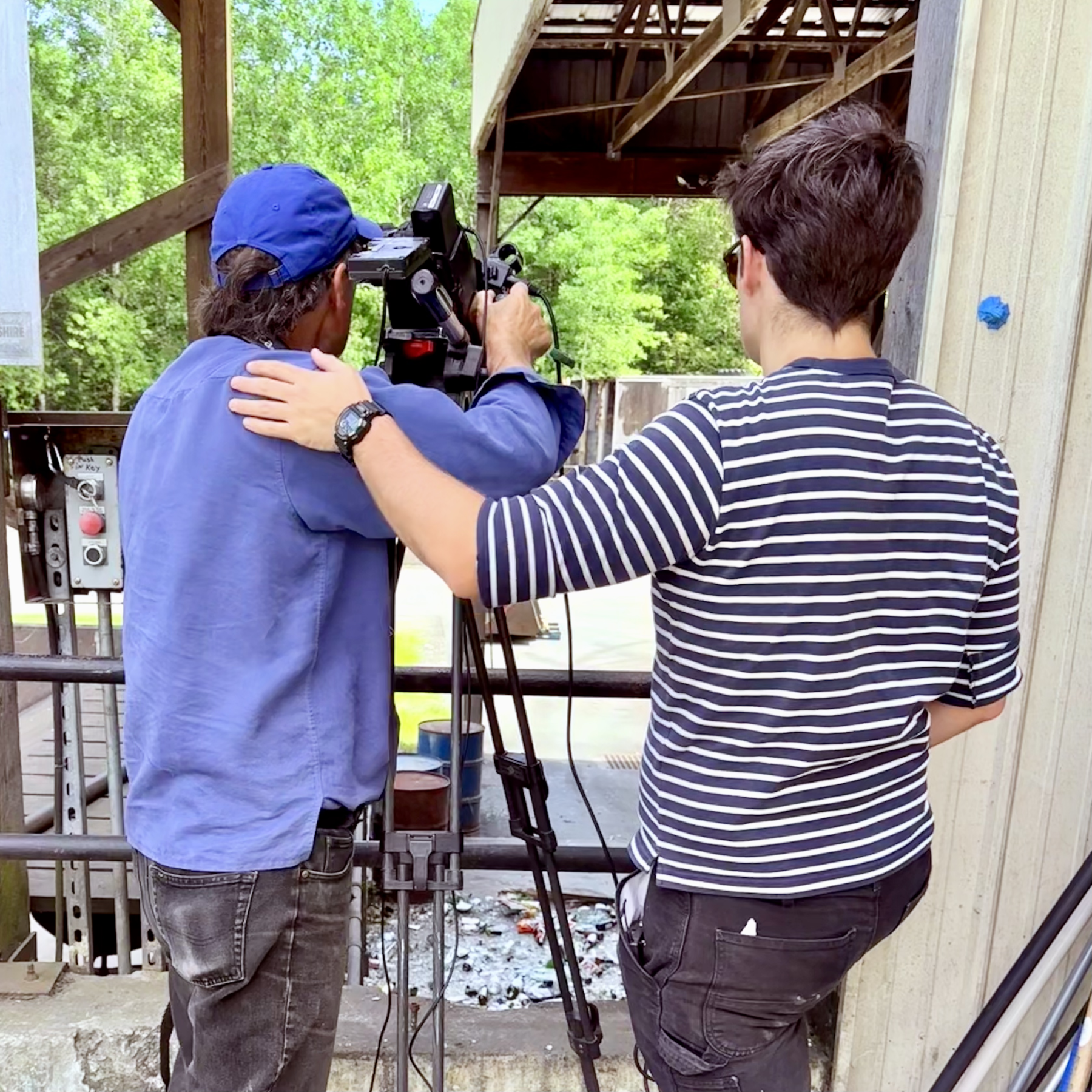 Two people filming a glass pile