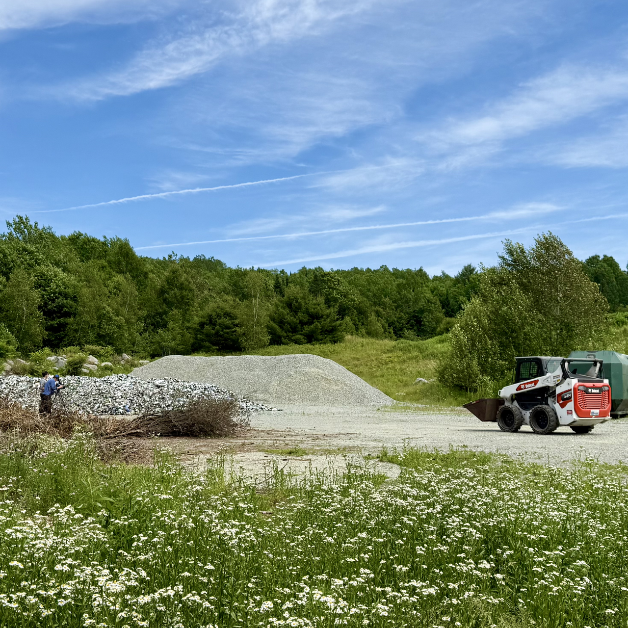 Filming a loader in front of a glass pile