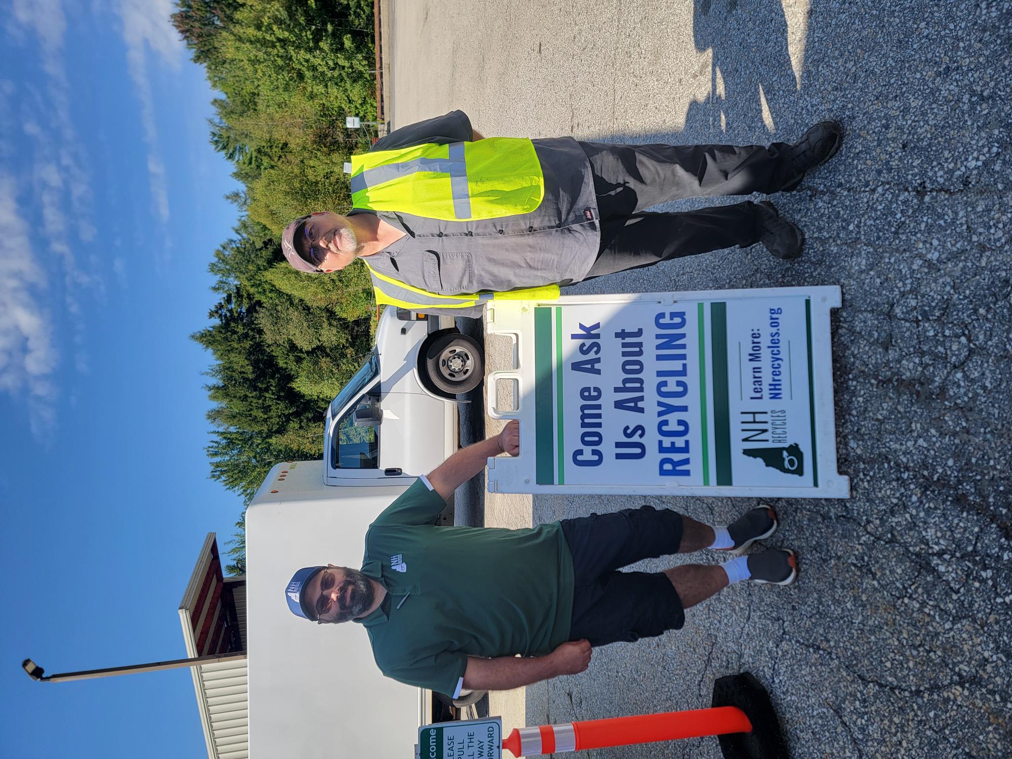 Brian and Paul with a sign that reads, "ask me about recycling"