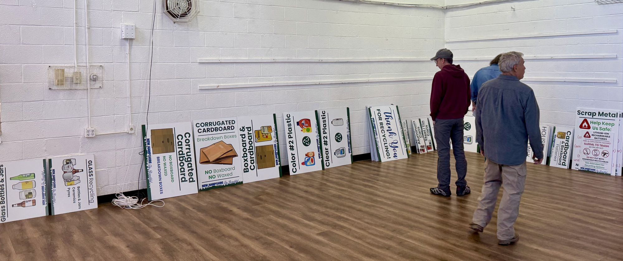 three men looking at transfer station signs