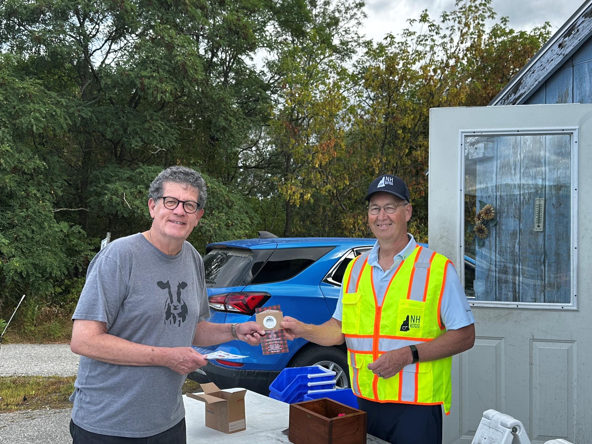 Two smiling people holding a gift card
