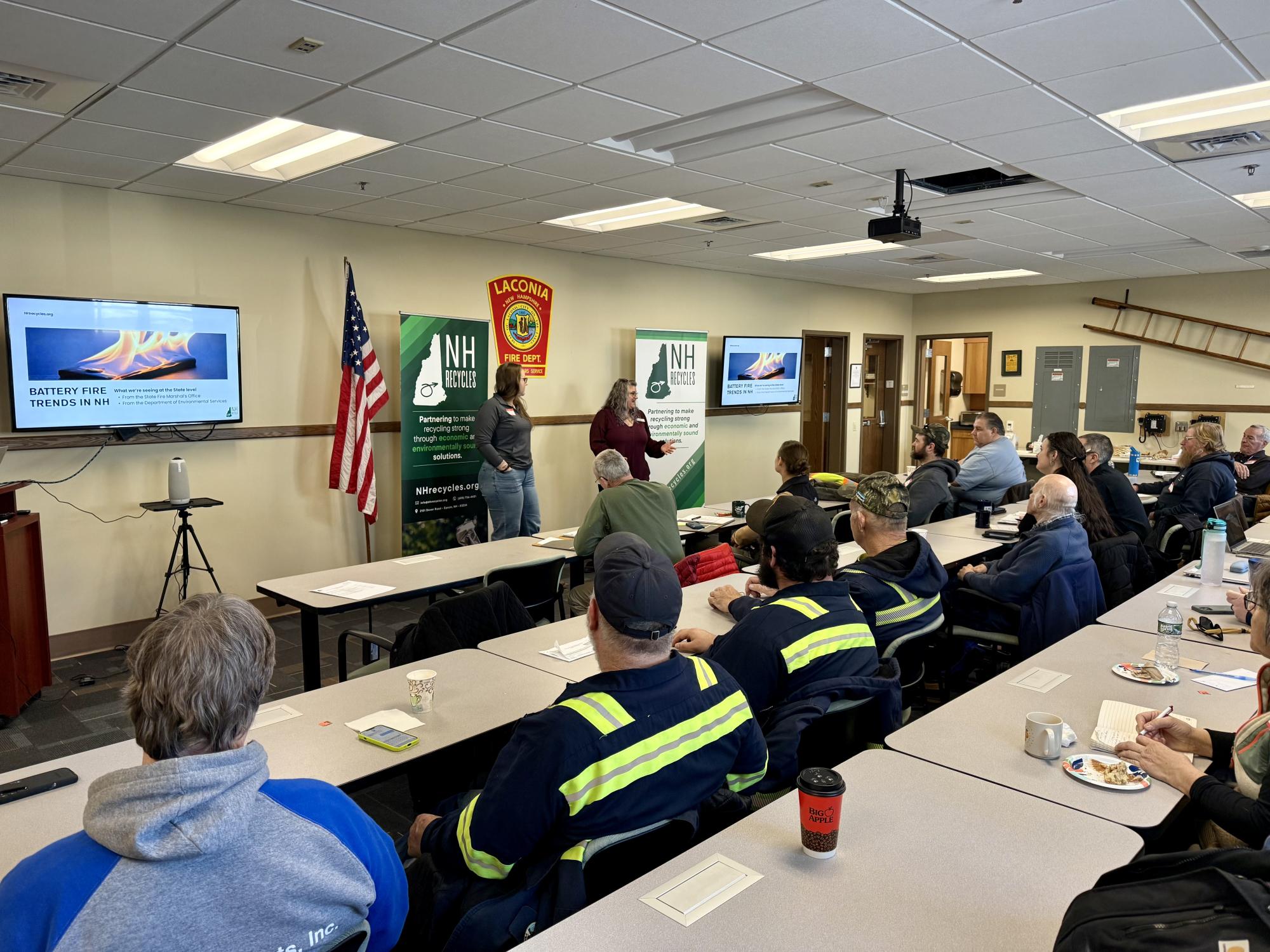 Two women talking to a group of people sitting at tables