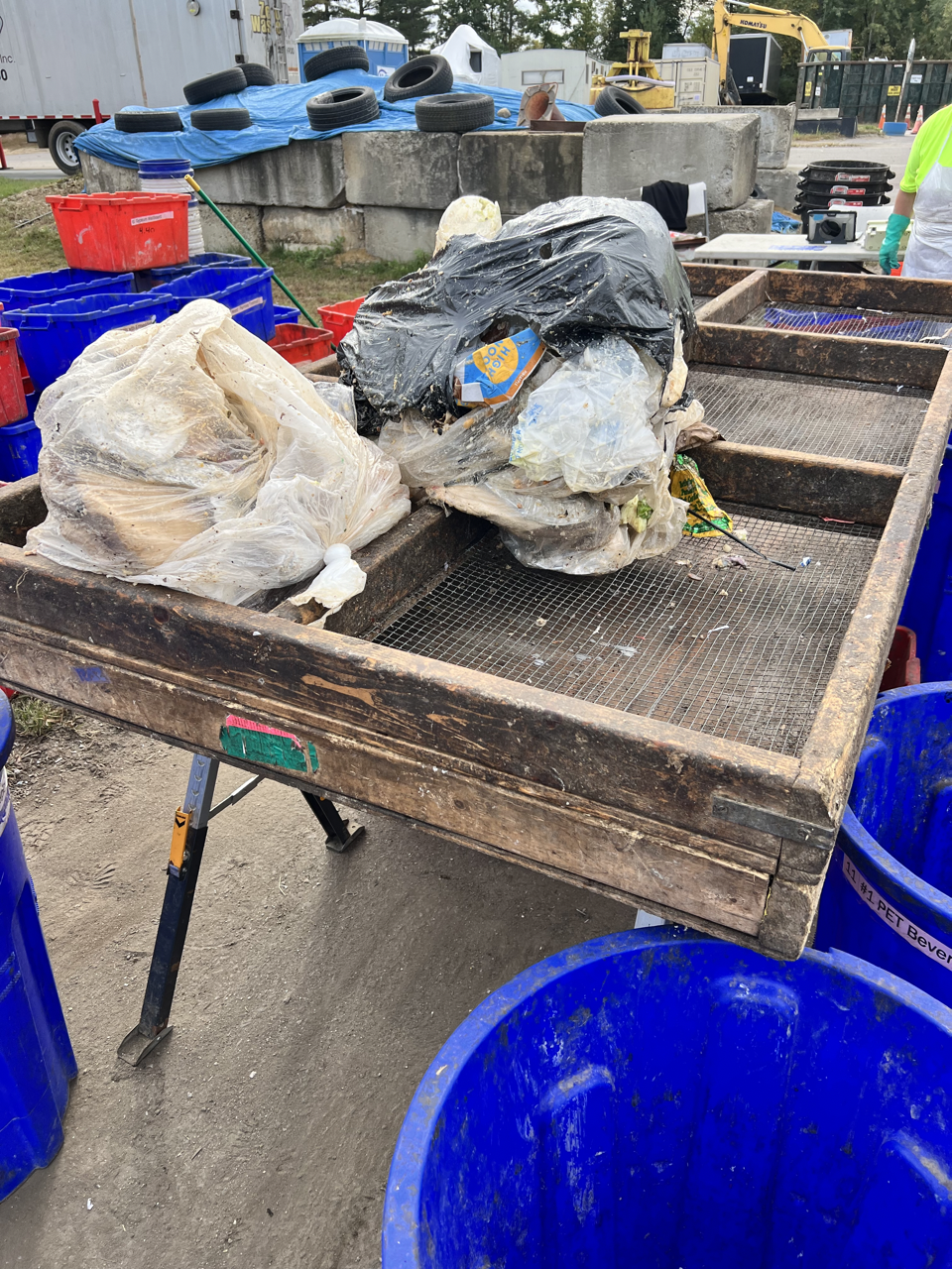 a trash sorting table with bags of trash on top