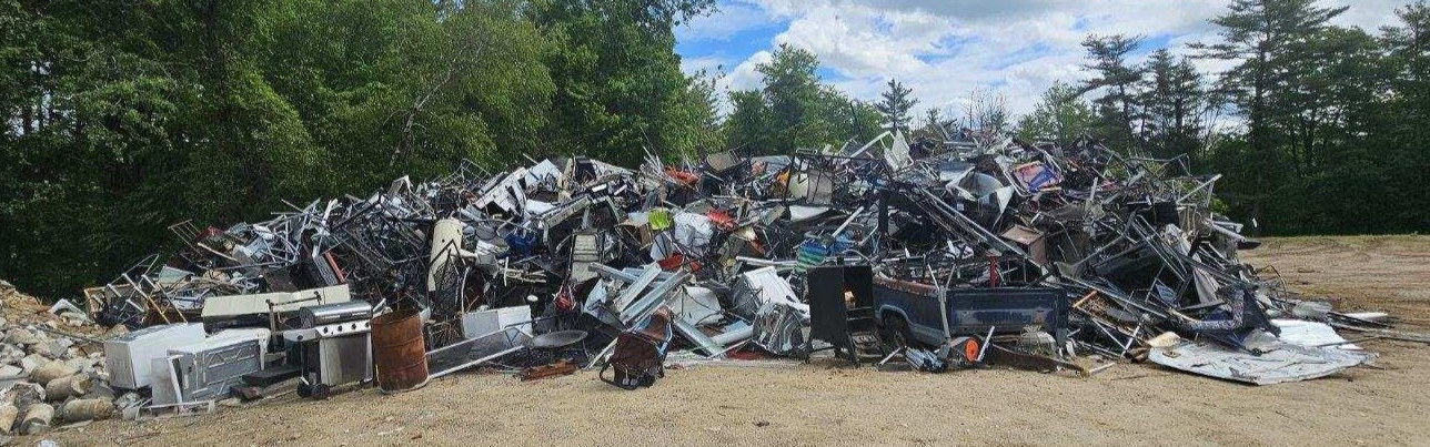 scrap metal pile on compacted soil at a transfer station
