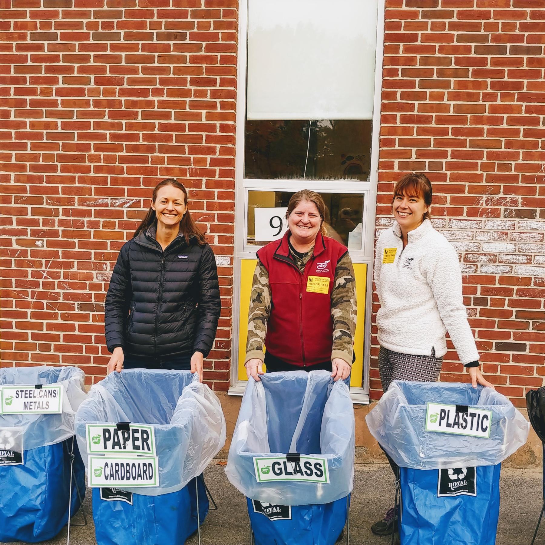 women standing with recycling bins
